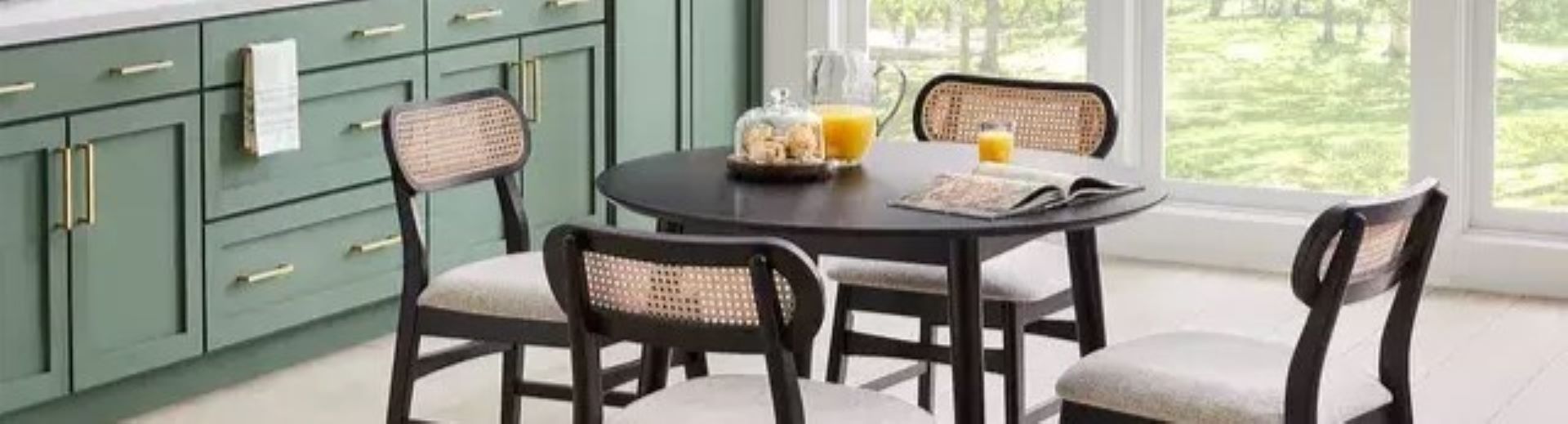 A kitchen with a round black table and four chairs.