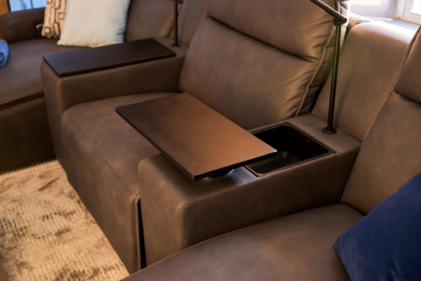 Brown leather sectional sofa with a built-in table and storage.
