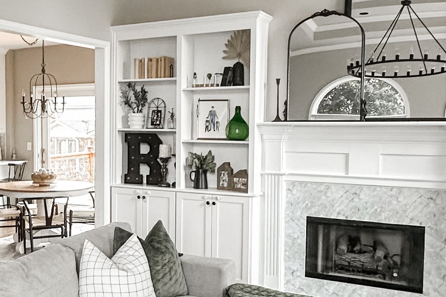 A living room with a fireplace, built-in shelves, and a sofa.
