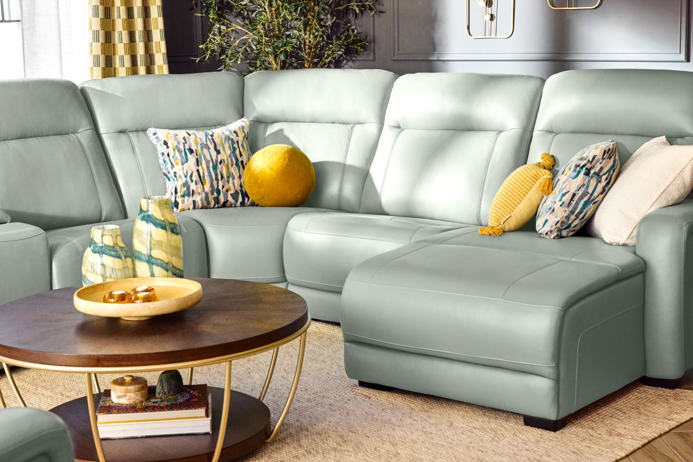 A light gray sectional sofa with decorative pillows and a round coffee table.
