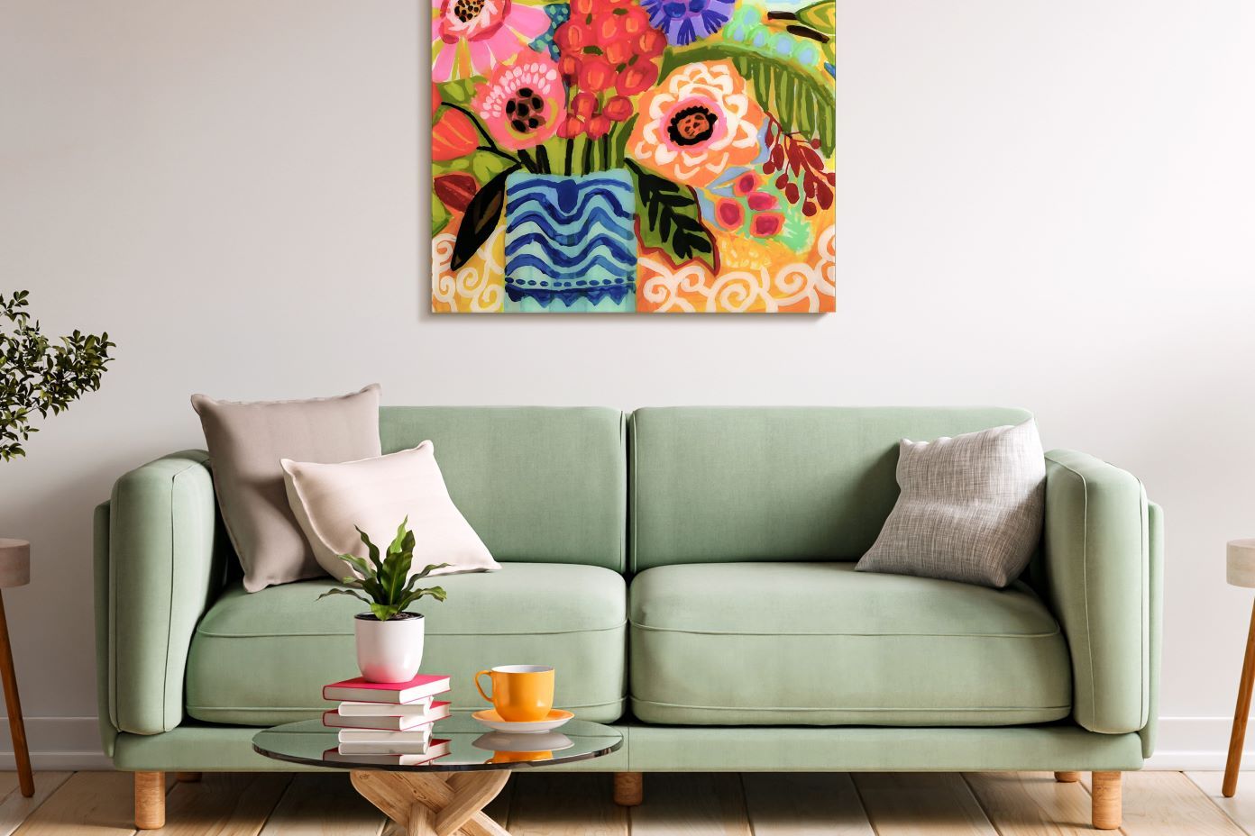 A green sofa with pillows, a coffee table, and a colorful floral painting.
