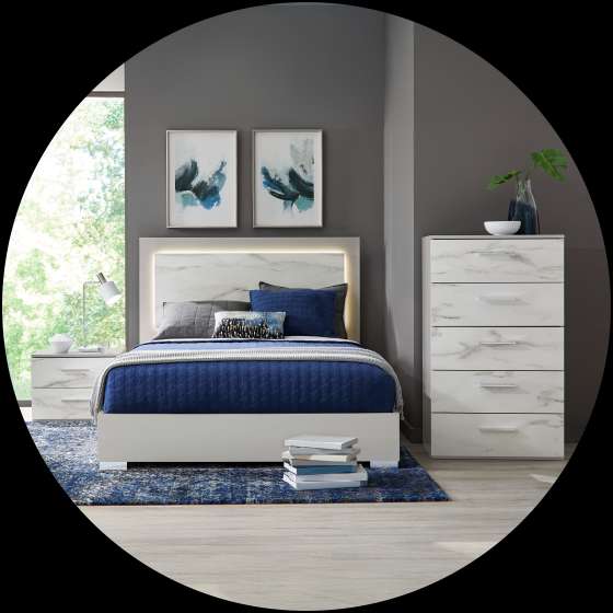 Bedroom set with a bed, nightstand, dresser, and artwork.
