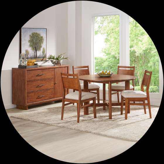 Dining room set with a round table, chairs, and a sideboard.
