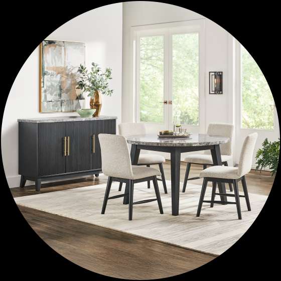 Dining room set with a round table, four chairs, and a black sideboard.
