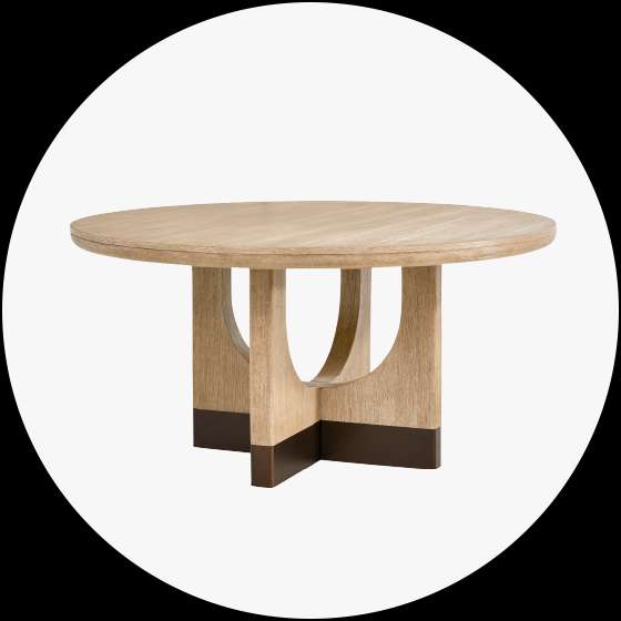 Round wooden dining table with a light wood top and a base with dark brown accents.
