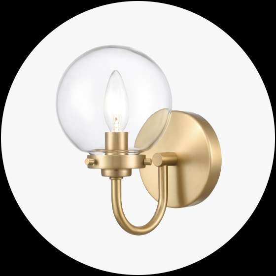 Gold wall sconce with a clear glass globe shade and a lit bulb.
