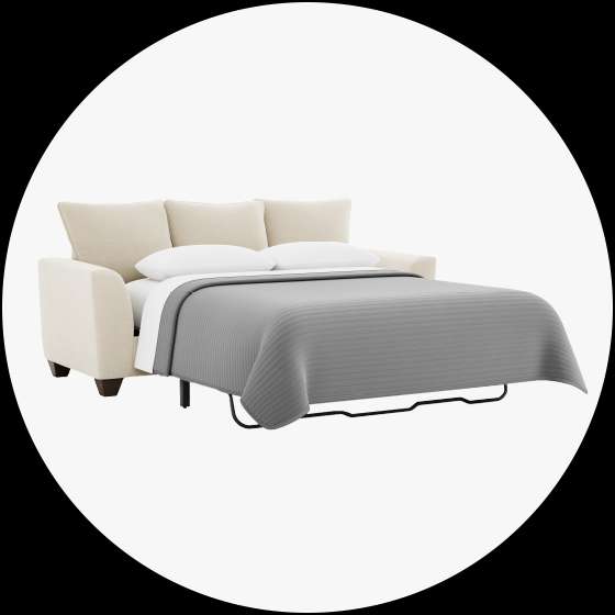 Beige sofa bed with a gray blanket.
