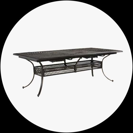 Outdoor dining table. Dark metal with decorative lattice and curved legs.
