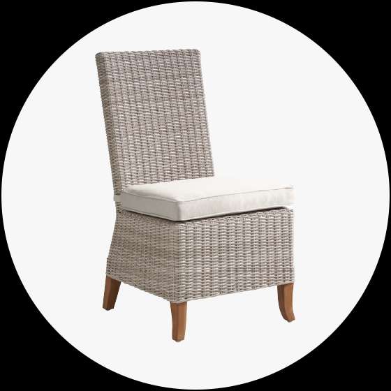 Wicker chair with a cream-colored cushion.
