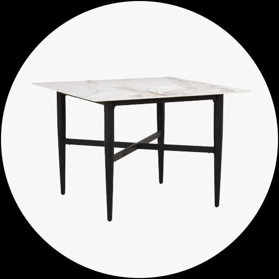 Square dining table with a white marble top and black legs.
