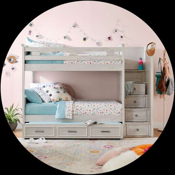 Bunk bed with storage drawers and a staircase, in a child's bedroom.
