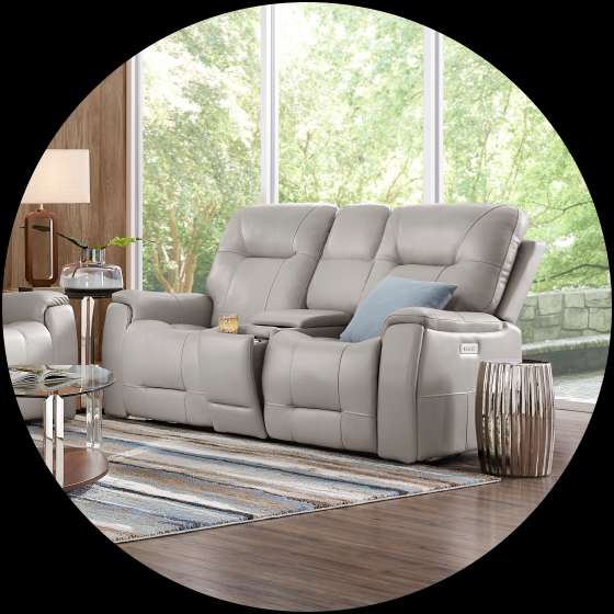 Gray leather reclining loveseat with a center console, in a living room.
