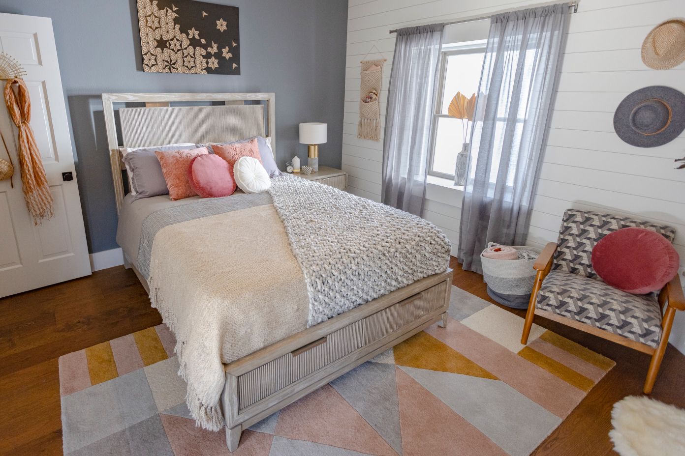 Bedroom with a bed, rug, chair, and window with curtains.
