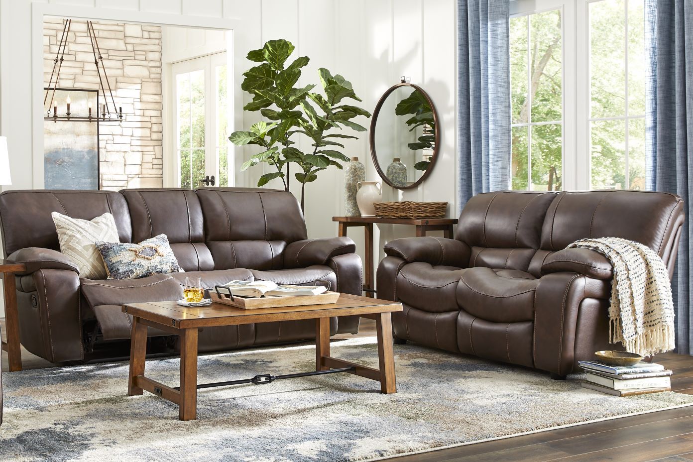 Brown leather reclining sofa and loveseat in a living room.
