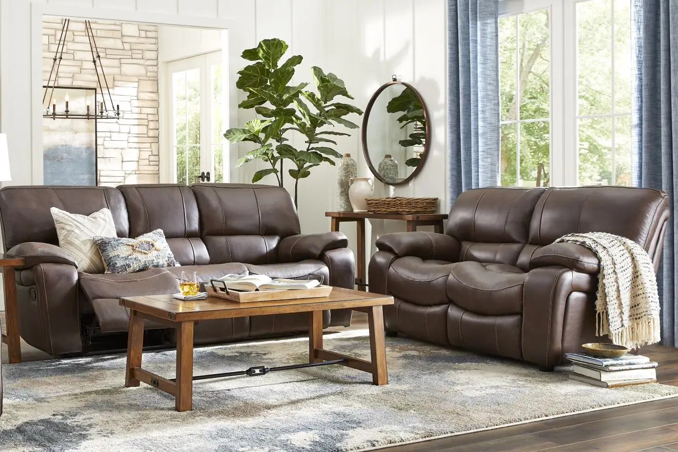 Brown leather reclining sofa and loveseat in a living room.
