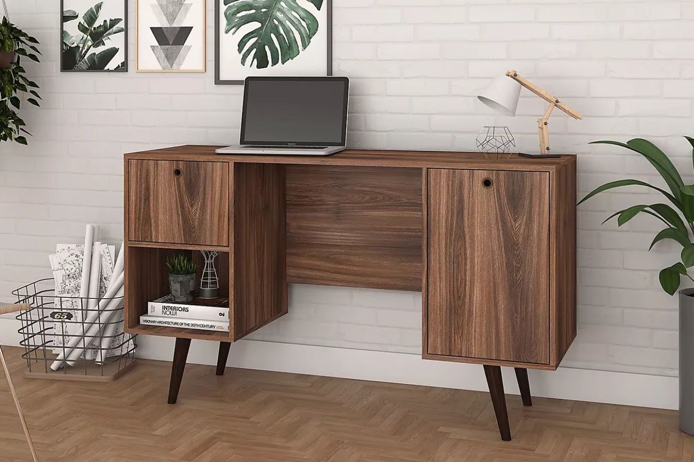 Wooden desk with a laptop, lamp, and decorative items.
