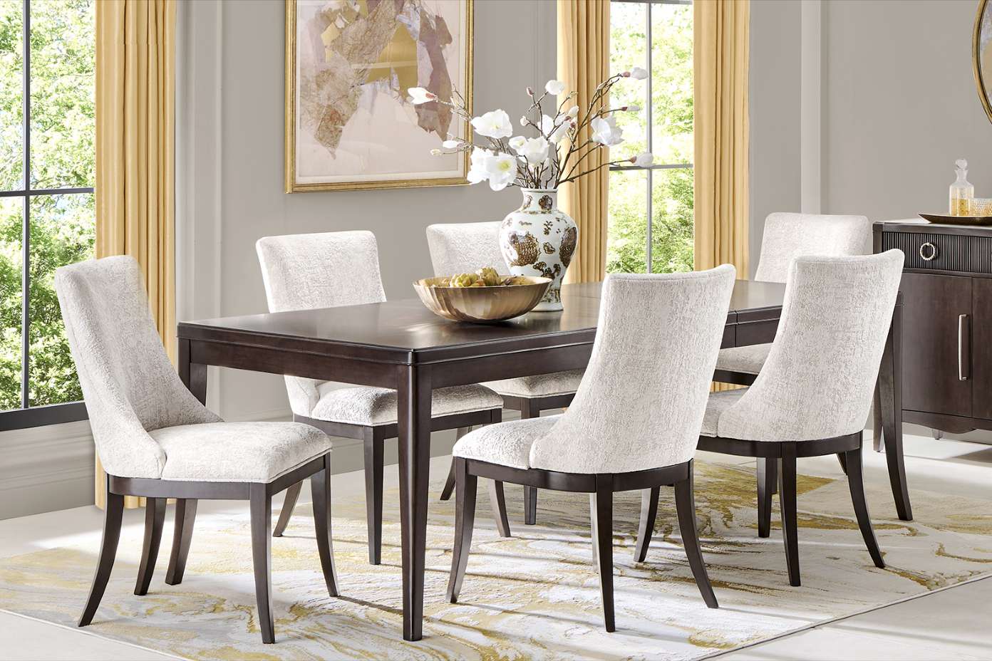 Dining room set with a dark wood table, six upholstered chairs, and a decorative vase.
