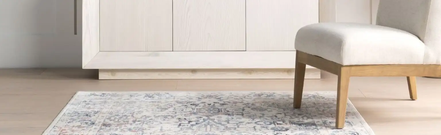 A light-colored rug with a chair and a white cabinet.