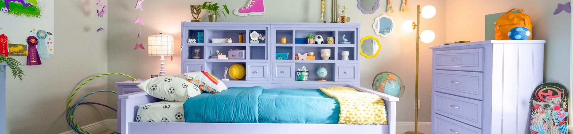 A child's bedroom with a purple bed, dresser, and headboard with shelves.
