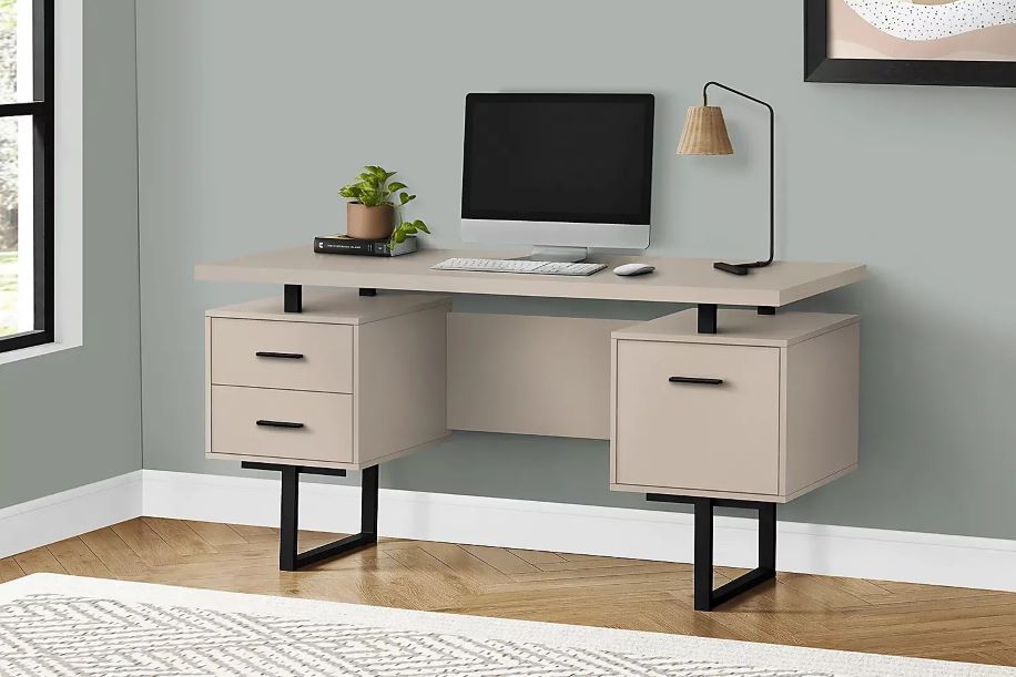Beige desk with black legs, drawers, and a computer.

