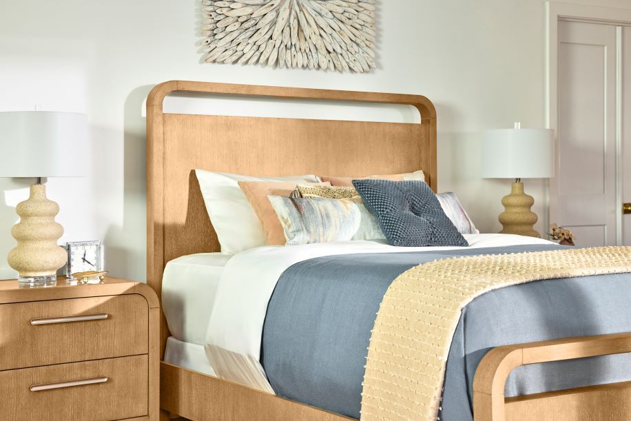 Wooden bed with a headboard, nightstand, and lamps.
