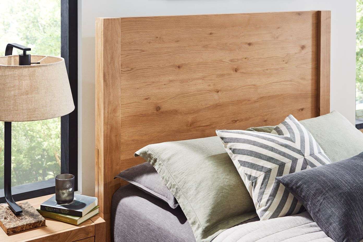 Wooden headboard with pillows and a lamp.
