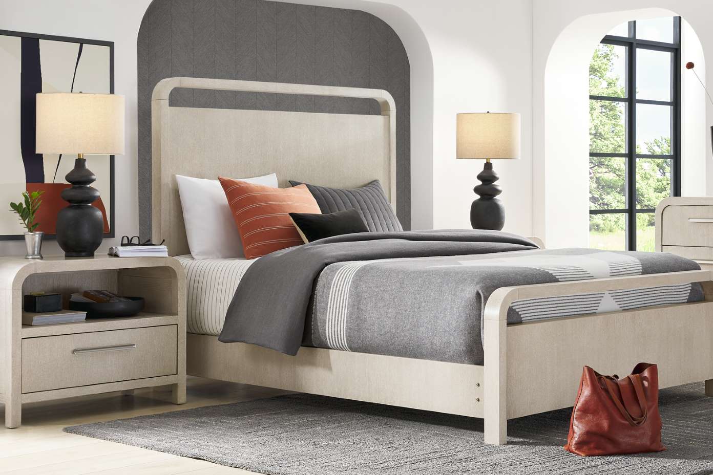 Bedroom set with a bed, nightstands, lamps, and a rug.
