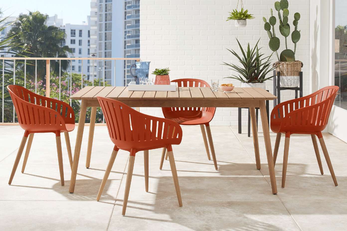 Outdoor dining set with orange chairs and a wooden table.
