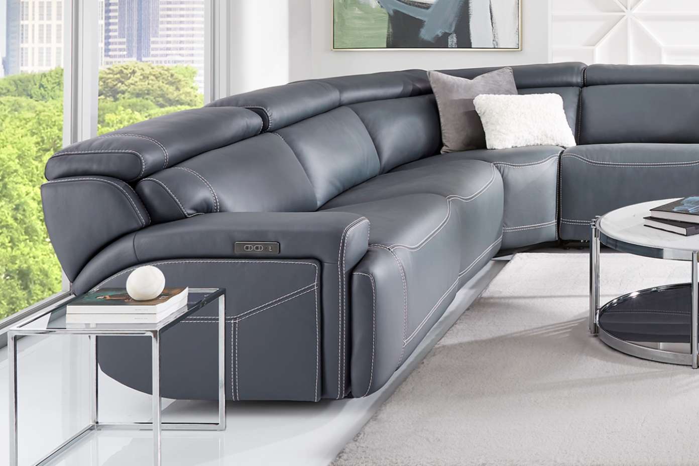 Gray leather sectional sofa with white stitching.