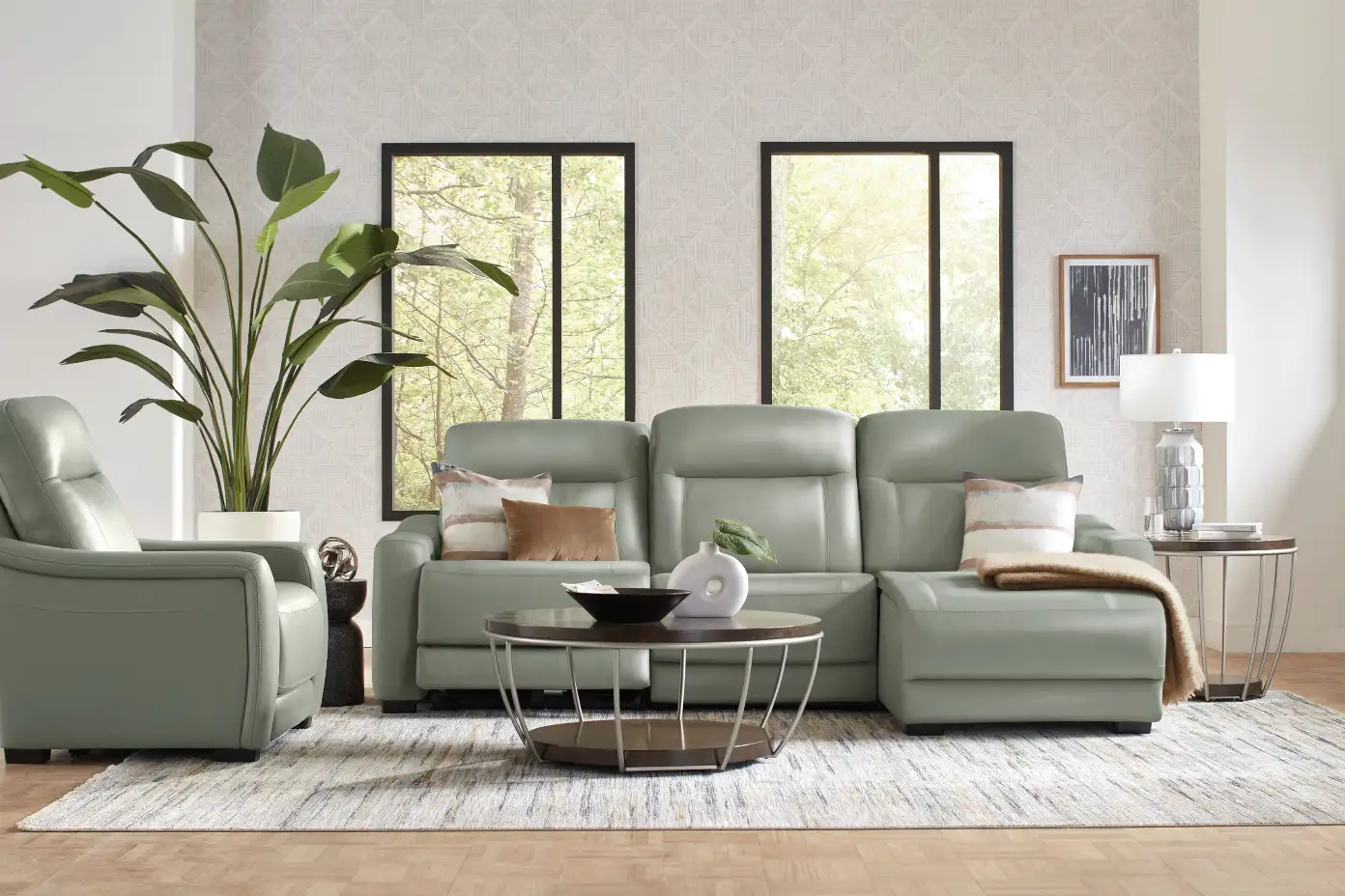 Green leather sectional sofa with a matching armchair, coffee table, and rug.