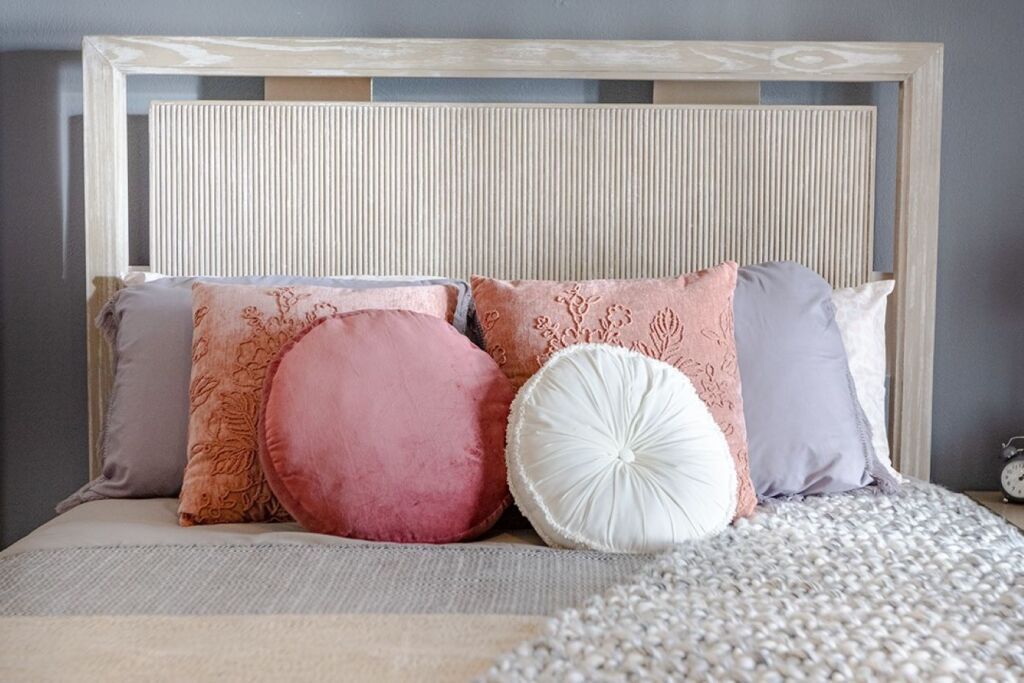 Bed with pillows and a gray blanket.
