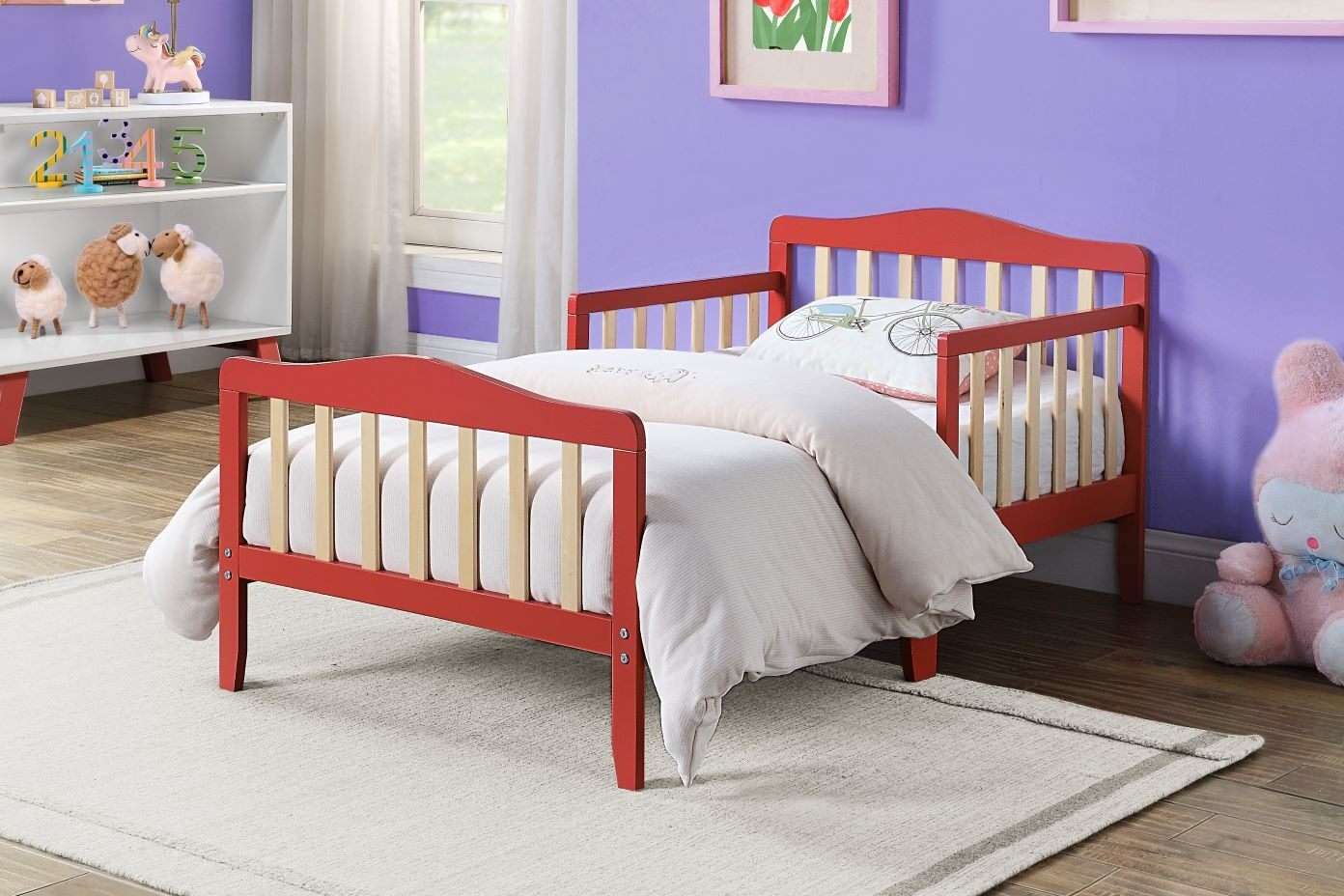 Red toddler bed in a child's room.
