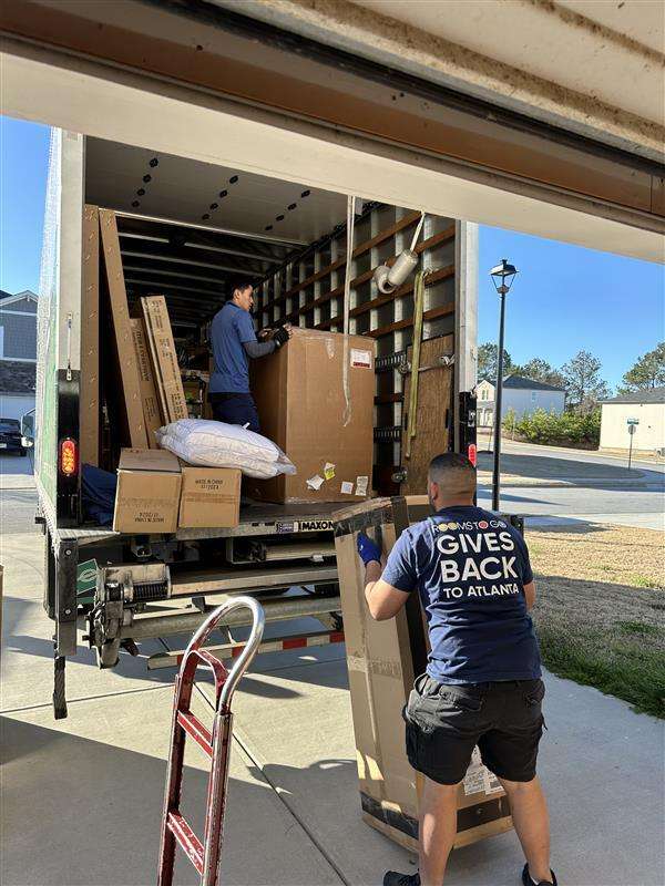 Rooms To Go Gives Back To Atlanta. Two men unloading furniture from a truck.