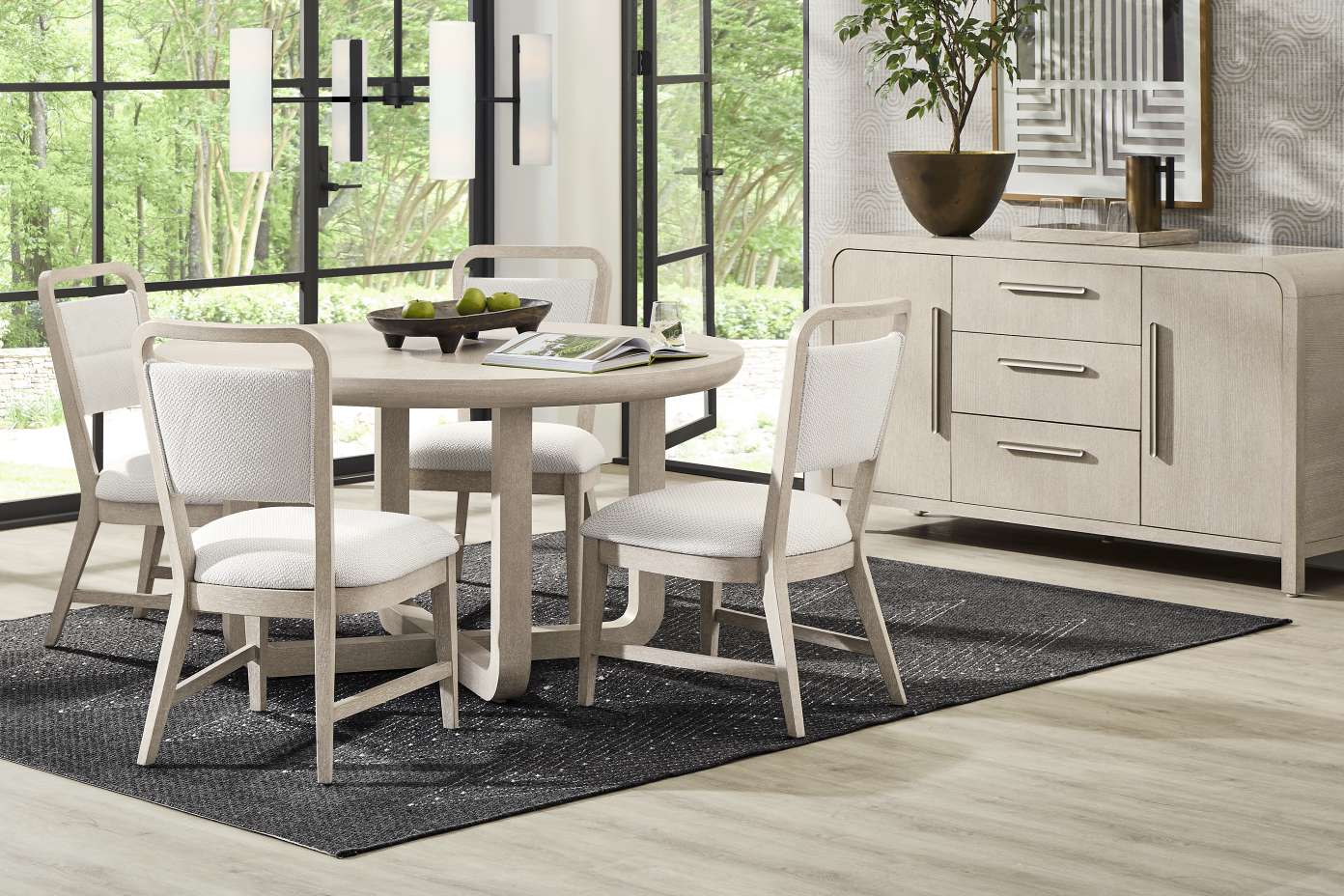 Dining room set with a round table, chairs, and a sideboard.