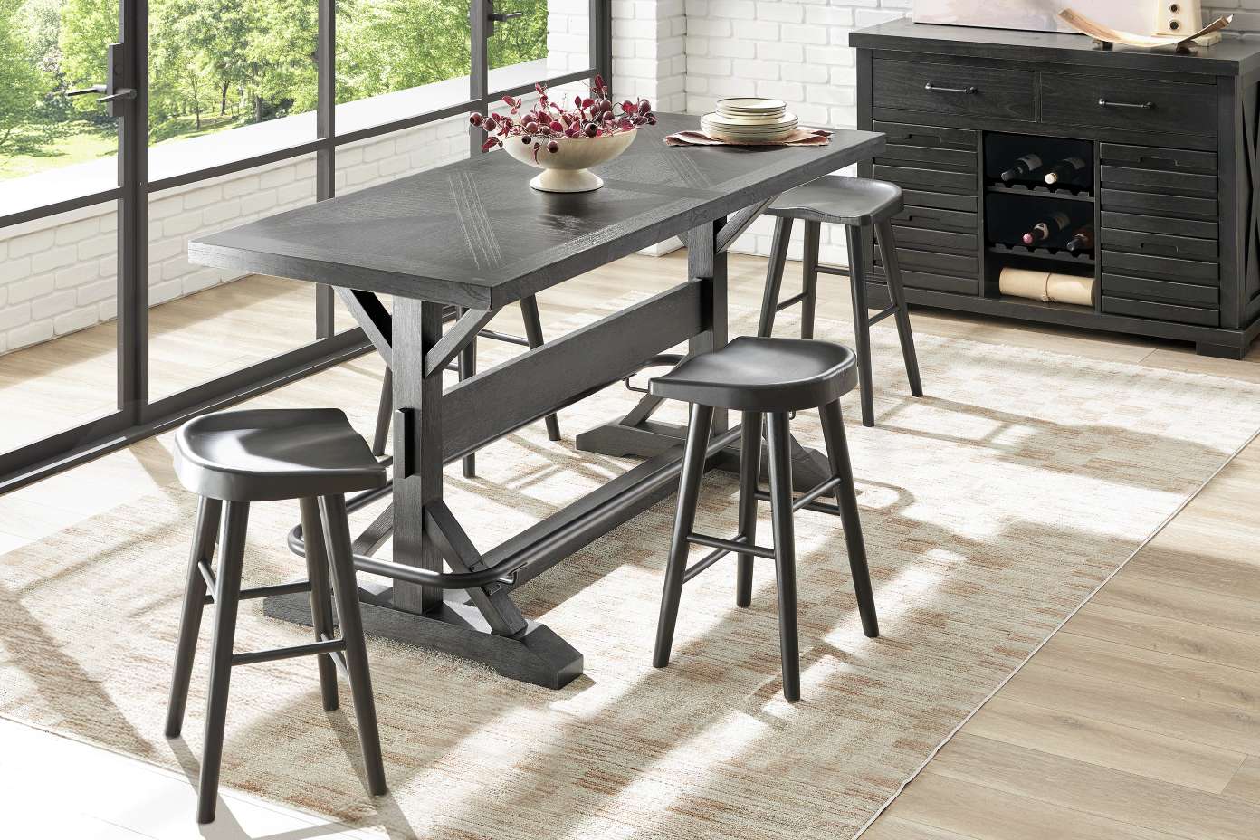 A dining table with four stools and a sideboard.
