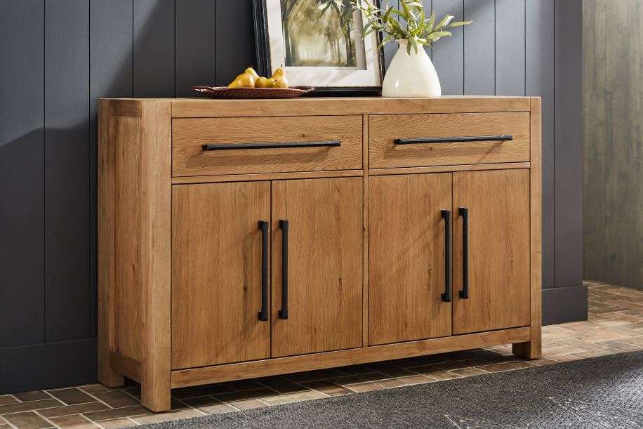 Wooden sideboard with drawers and doors, black handles.
