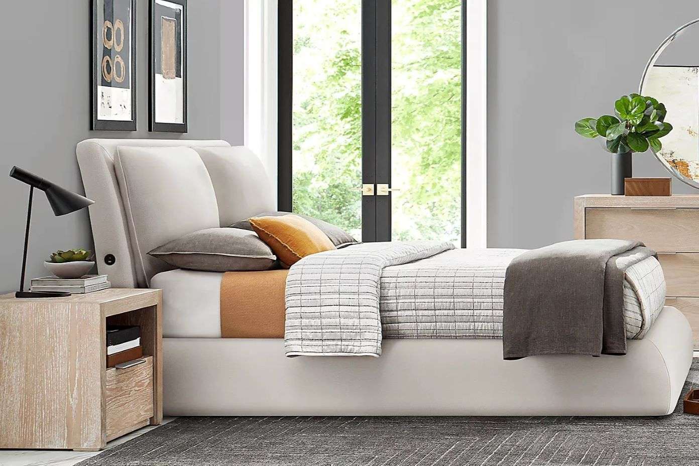 A modern bed with a white headboard, a wooden nightstand, and a black lamp.