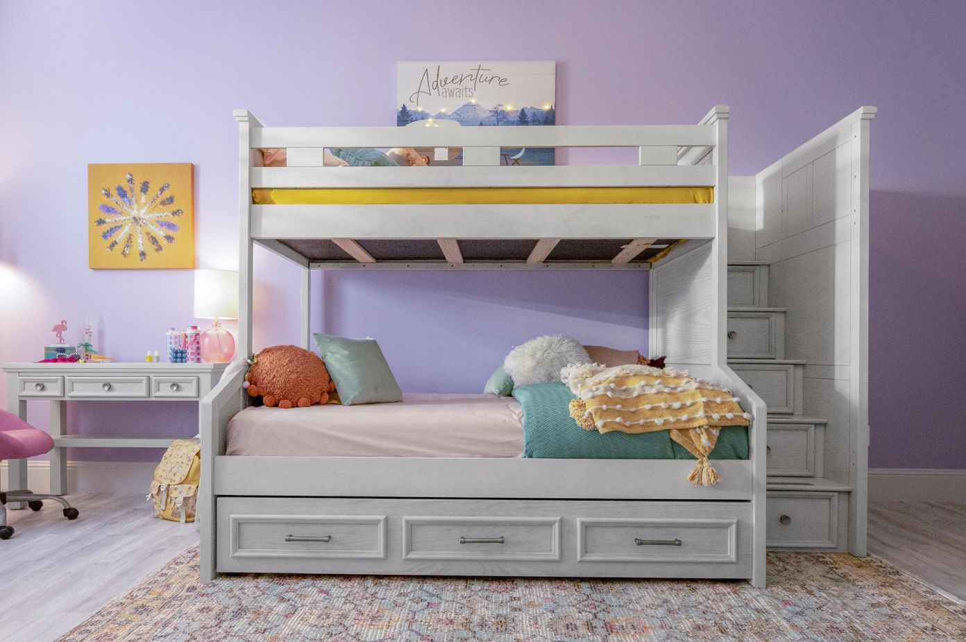 White bunk bed with stairs and storage drawers.

