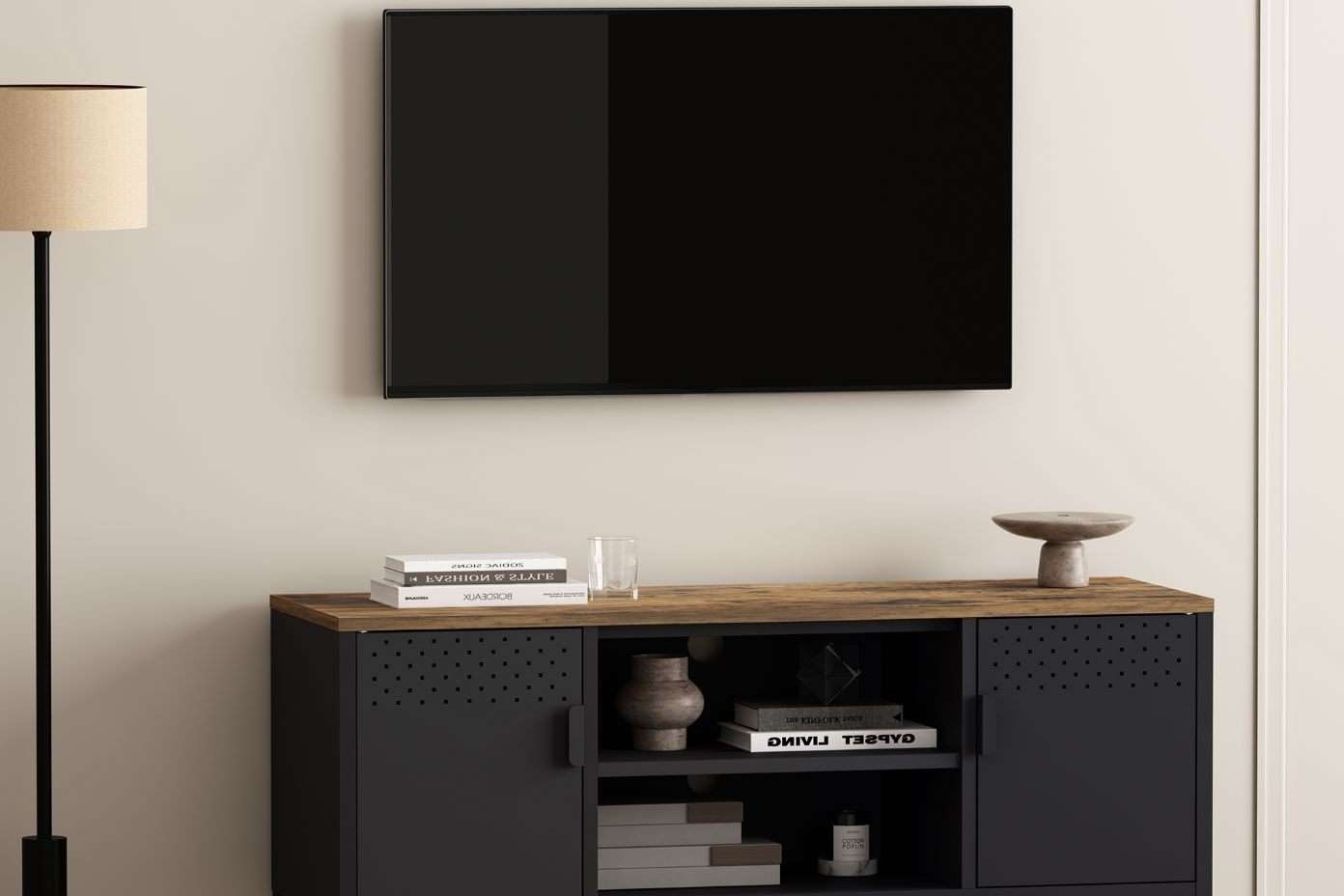 A black TV mounted on a wall above a black cabinet with a wooden top.
