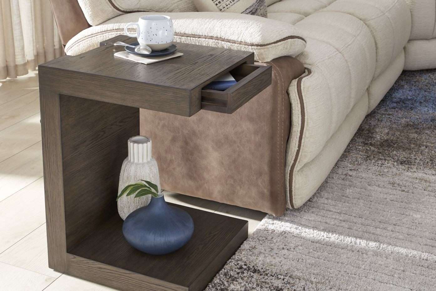 Wooden side table with a drawer, a mug, and decorative vases.
