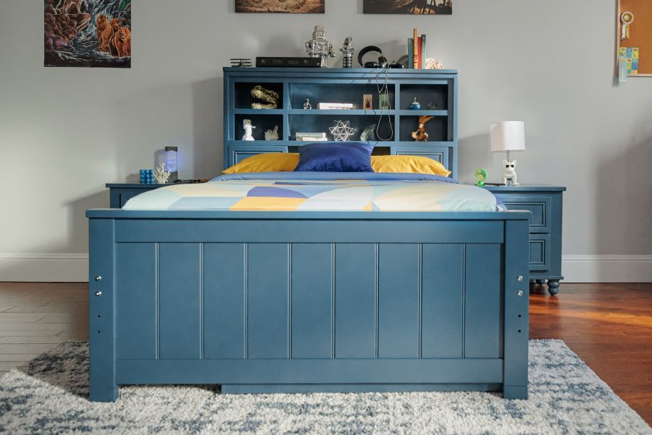 Blue bed with a headboard and nightstands.
