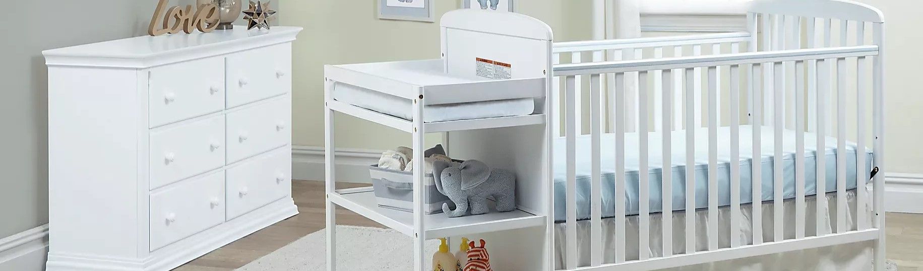 White baby crib, changing table, and dresser.
