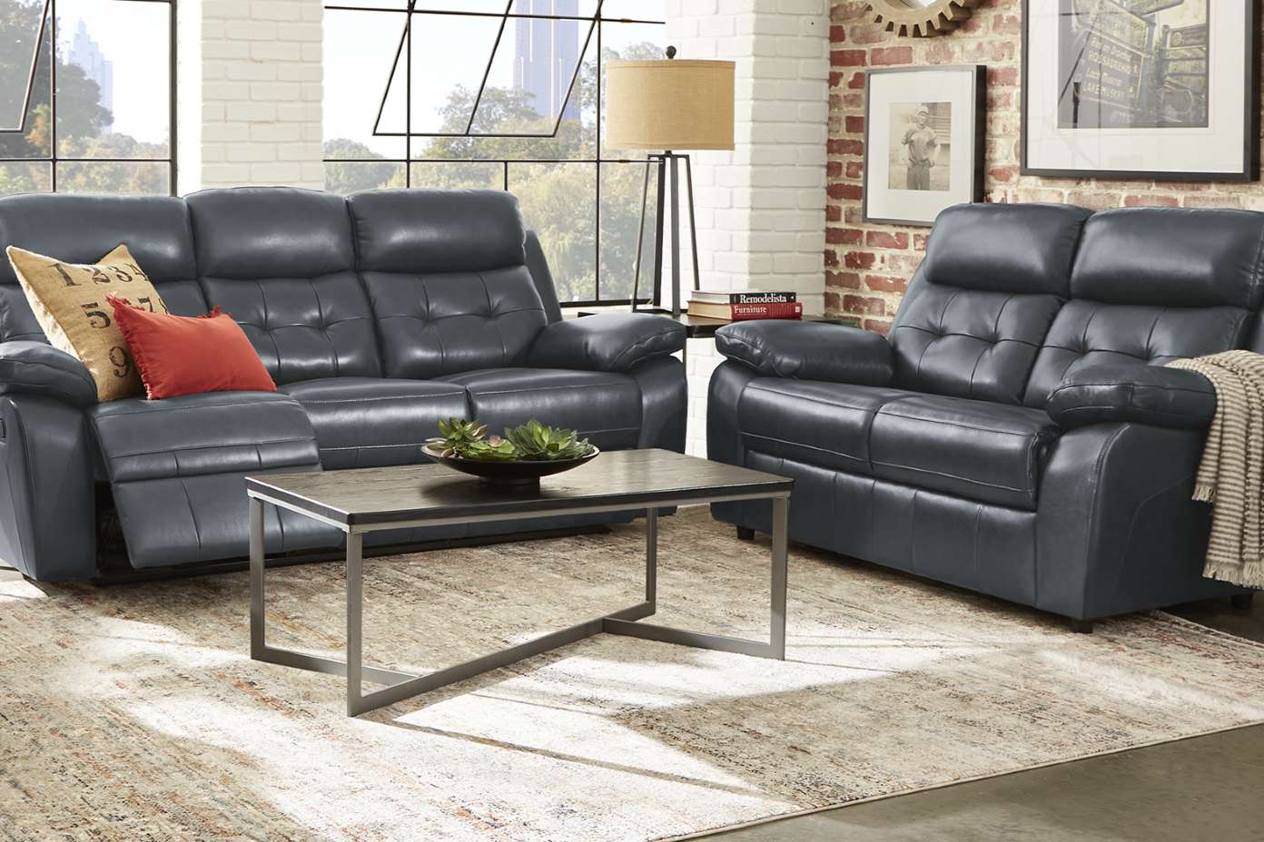 A living room with a gray leather sofa and loveseat, a coffee table, and a rug.
