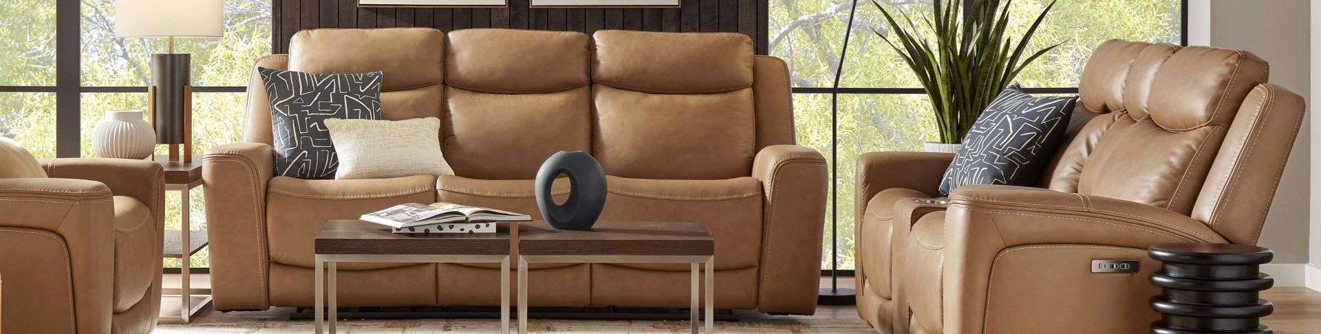 Brown leather reclining sofa with pillows and a coffee table.