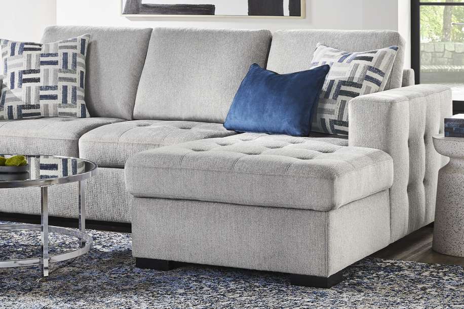 Gray sectional sofa with a chaise lounge and patterned throw pillows.