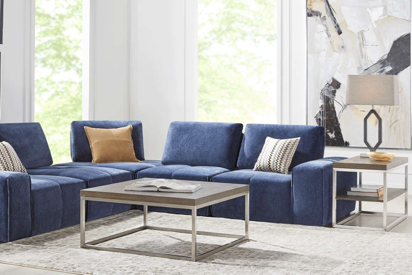 Blue sectional sofa with a square coffee table and side table.
