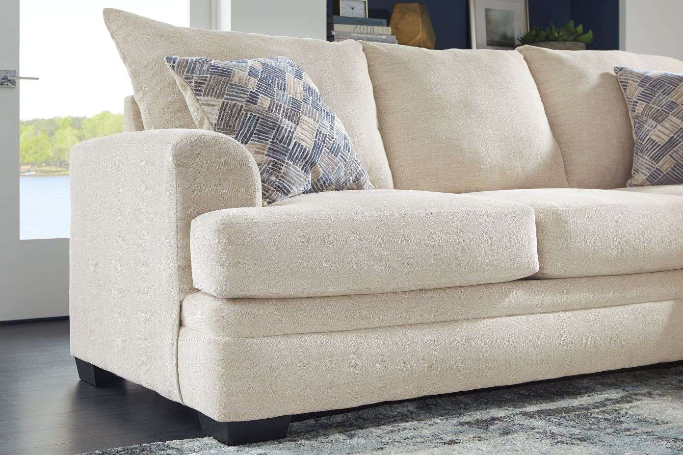 Beige sofa with patterned pillows.