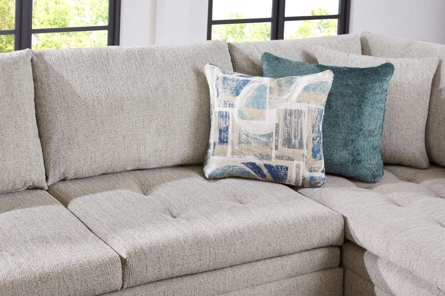 A light gray sectional sofa with decorative pillows.
