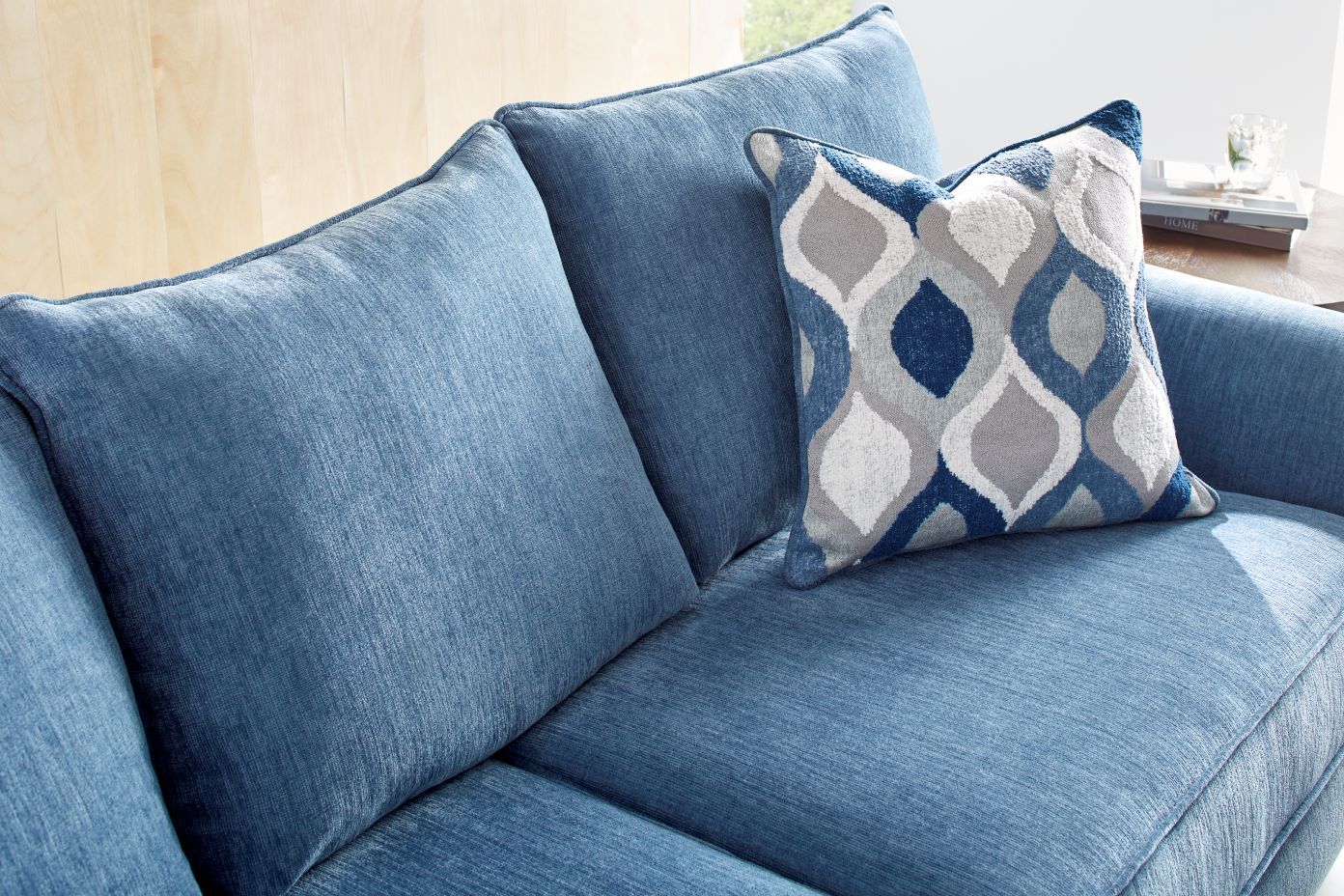Blue sofa with patterned pillow.
