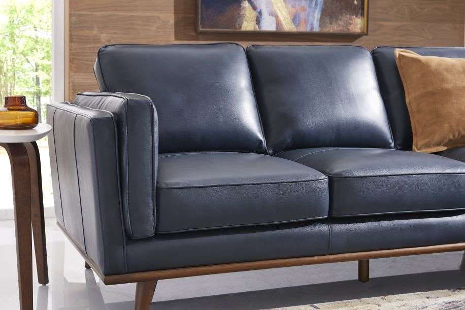 Blue leather sofa with wooden legs.
